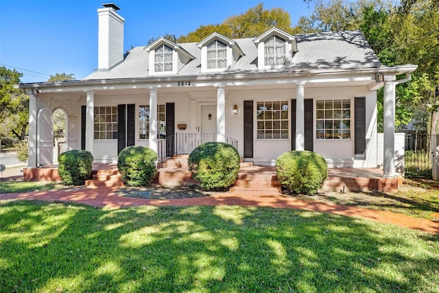 new england style home with a porch and a front yard