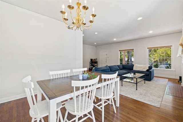 dining space with dark hardwood / wood-style flooring and an inviting chandelier