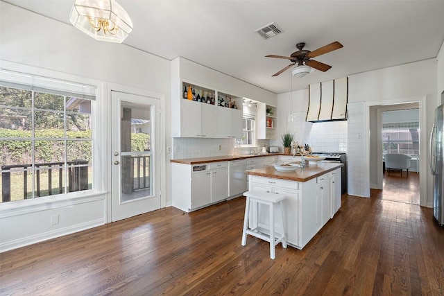 kitchen with dark wood-type flooring, butcher block counters, white cabinetry, a center island, and white dishwasher