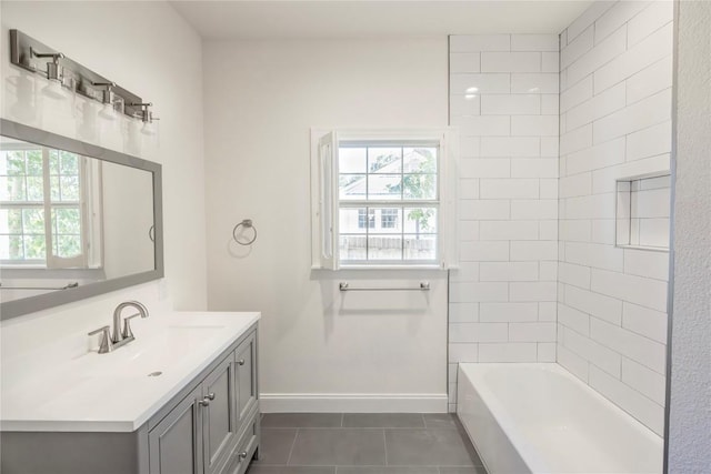 bathroom featuring tile patterned floors, tiled shower / bath combo, vanity, and a wealth of natural light