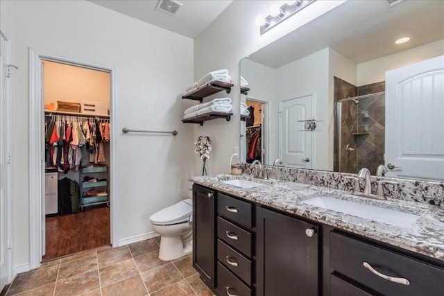 bathroom with walk in shower, vanity, and toilet