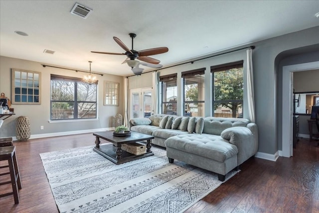 living room with dark wood-type flooring and ceiling fan with notable chandelier