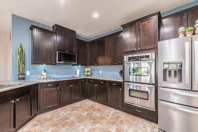 kitchen with light stone countertops, appliances with stainless steel finishes, and dark brown cabinetry