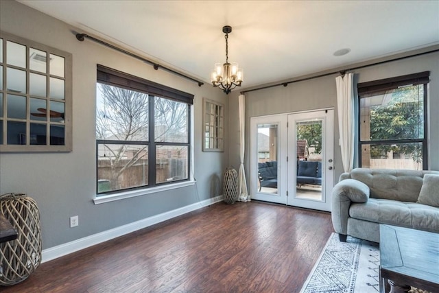 entryway with dark wood-type flooring and an inviting chandelier