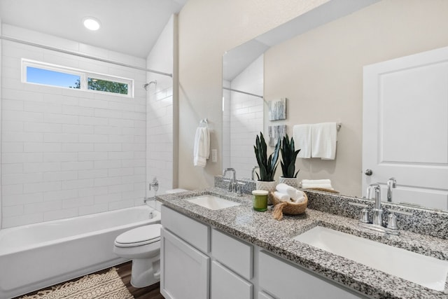 full bathroom with vanity, toilet, hardwood / wood-style floors, and tiled shower / bath