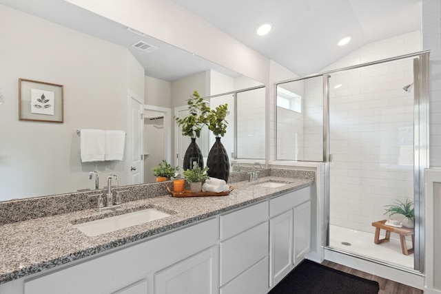 bathroom with vanity, wood-type flooring, a shower with shower door, and vaulted ceiling