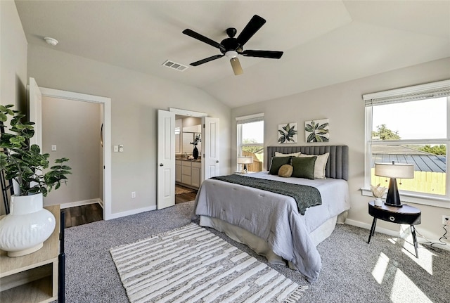 bedroom featuring multiple windows, vaulted ceiling, ceiling fan, and ensuite bath