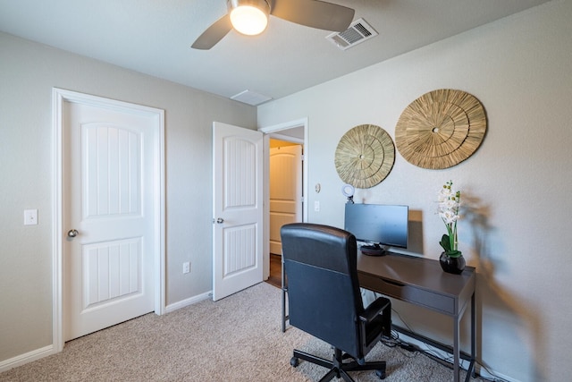 carpeted office space featuring ceiling fan