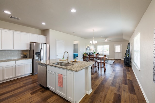 kitchen with sink, a center island with sink, appliances with stainless steel finishes, light stone countertops, and white cabinets