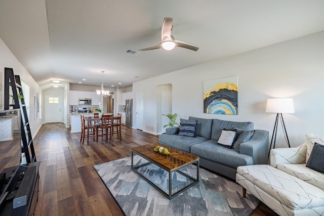 living room featuring vaulted ceiling, dark hardwood / wood-style floors, and ceiling fan with notable chandelier