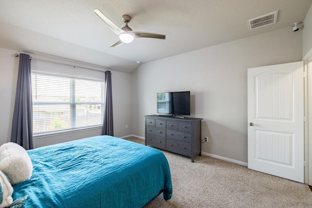 bedroom with ceiling fan, vaulted ceiling, and light carpet