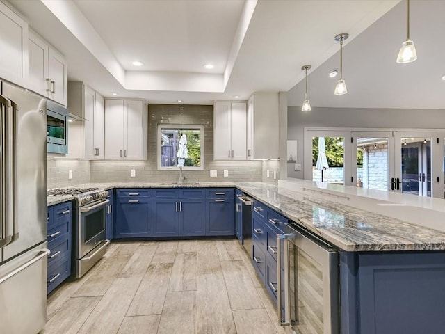 kitchen featuring stainless steel appliances, beverage cooler, kitchen peninsula, and white cabinets