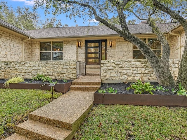 doorway to property featuring a lawn