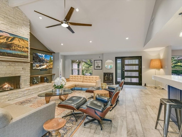 living room featuring light hardwood / wood-style flooring, ceiling fan, beam ceiling, high vaulted ceiling, and a fireplace