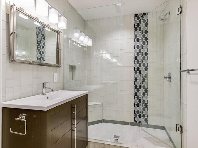 bathroom featuring vanity, tile walls, an enclosed shower, and backsplash