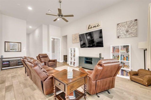 living room with ceiling fan and light hardwood / wood-style flooring