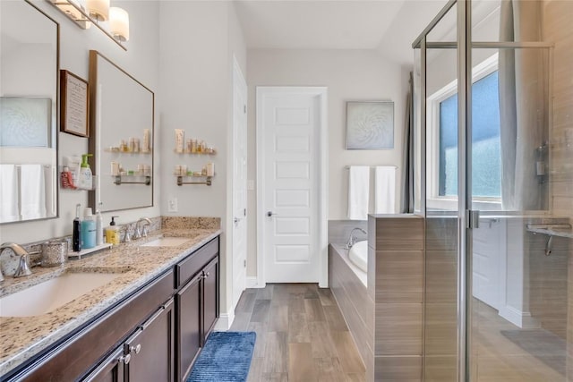 bathroom with hardwood / wood-style flooring, vanity, and shower with separate bathtub