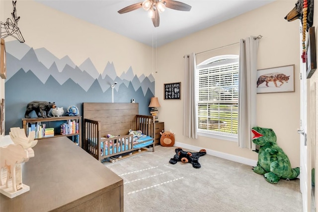 bedroom featuring carpet floors, a nursery area, and ceiling fan