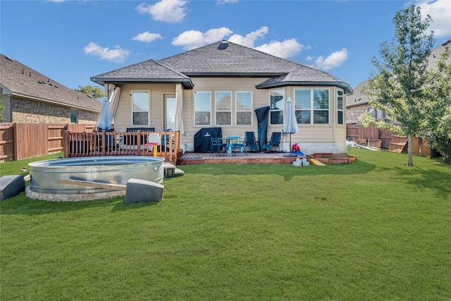 back of house with a pool side deck and a yard