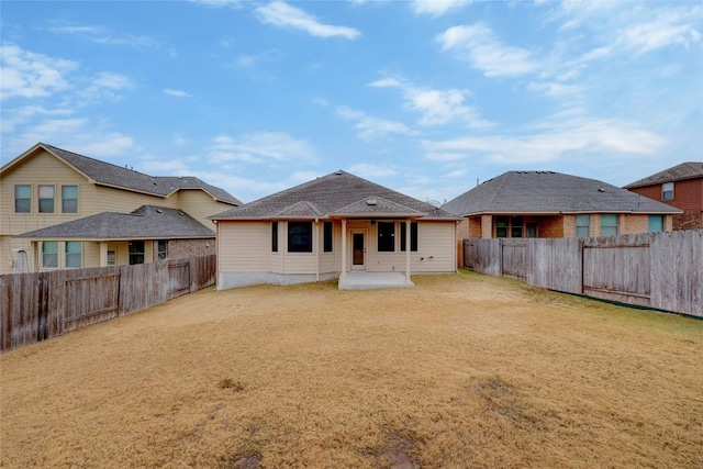 rear view of property featuring a patio area and a lawn