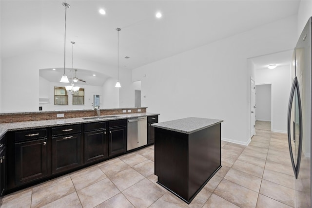 kitchen with sink, decorative light fixtures, a center island, stainless steel appliances, and light stone countertops