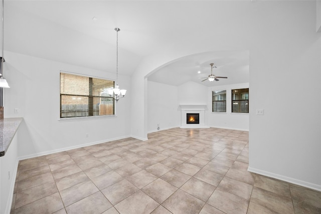 unfurnished living room featuring light tile patterned flooring, lofted ceiling, and ceiling fan with notable chandelier