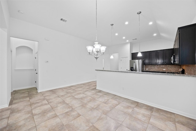 kitchen featuring backsplash, stainless steel refrigerator with ice dispenser, light stone counters, a notable chandelier, and decorative light fixtures