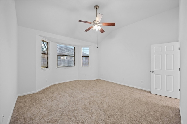 spare room featuring ceiling fan, light colored carpet, and lofted ceiling