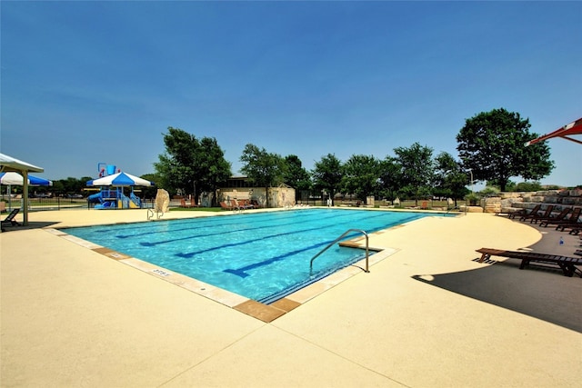 view of swimming pool featuring a playground and a patio area