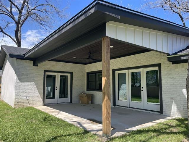 rear view of house with a patio area, french doors, and a lawn