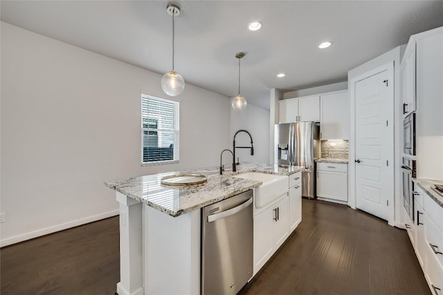 kitchen with white cabinetry, sink, stainless steel appliances, and a center island with sink