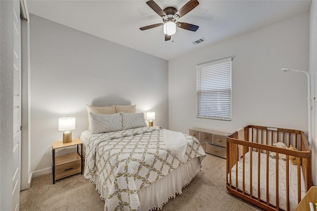 bedroom featuring light carpet and ceiling fan