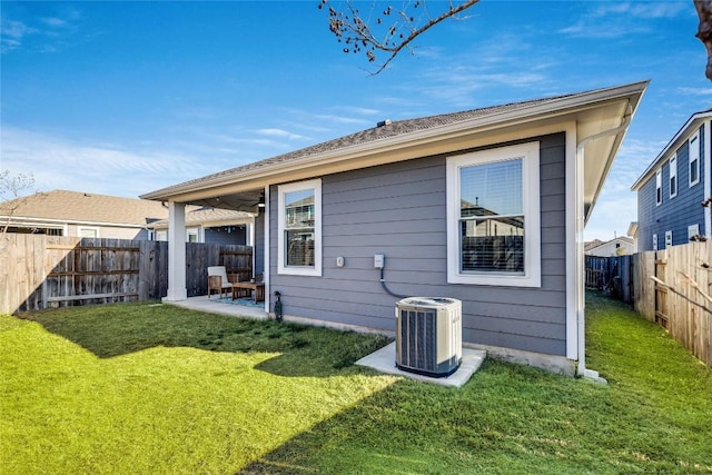 back of property with central AC, a yard, and a patio area