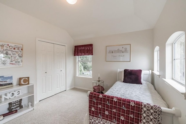 carpeted bedroom featuring vaulted ceiling and a closet