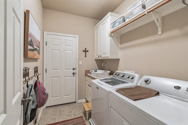 laundry area with cabinets, washing machine and clothes dryer, and sink