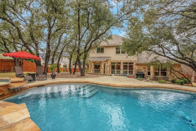 view of swimming pool featuring pool water feature and a patio