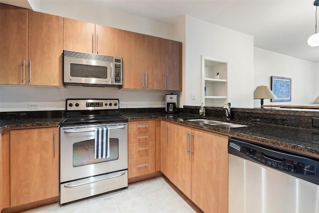 kitchen featuring light tile patterned flooring, sink, dark stone countertops, pendant lighting, and stainless steel appliances