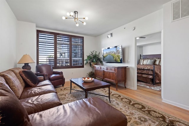 living room with an inviting chandelier and light hardwood / wood-style floors