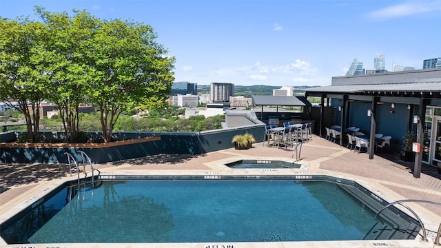 view of swimming pool featuring a hot tub, exterior bar, and a patio area