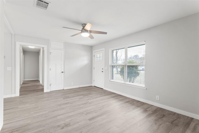 empty room with ceiling fan and light hardwood / wood-style flooring