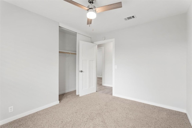 unfurnished bedroom featuring light colored carpet, ceiling fan, and a closet