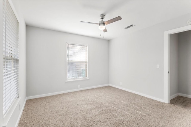 carpeted spare room featuring ceiling fan