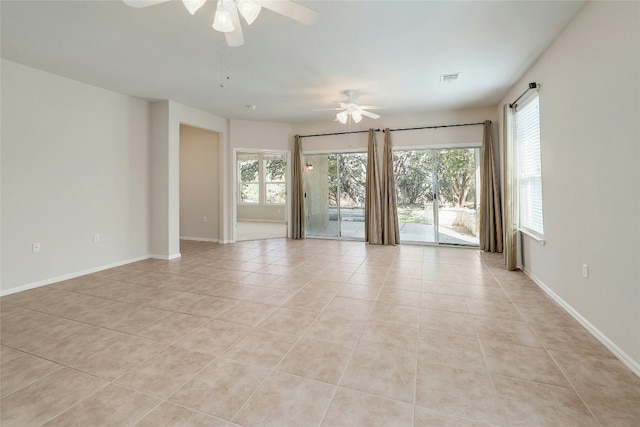 tiled empty room with a wealth of natural light and ceiling fan