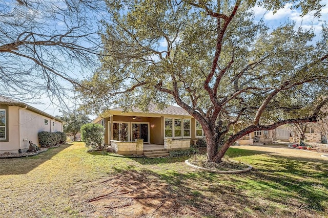 back of house with a yard and ceiling fan