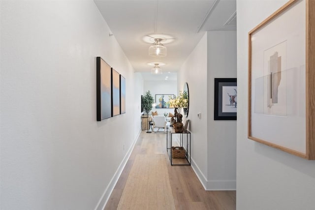 hallway with light hardwood / wood-style floors