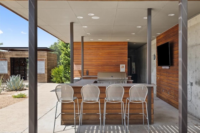 view of patio / terrace featuring a grill, exterior bar, and exterior kitchen