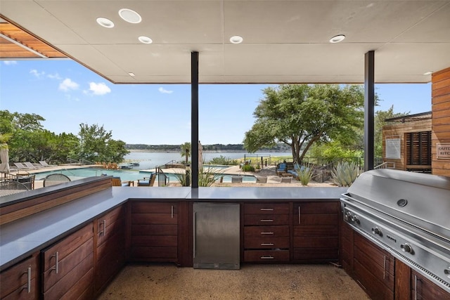 view of patio / terrace with a water view and a grill