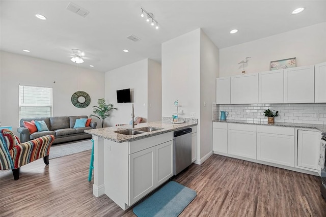 kitchen with sink, light hardwood / wood-style flooring, dishwasher, white cabinetry, and kitchen peninsula