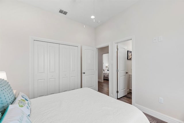 bedroom with dark hardwood / wood-style flooring, ensuite bath, and a closet