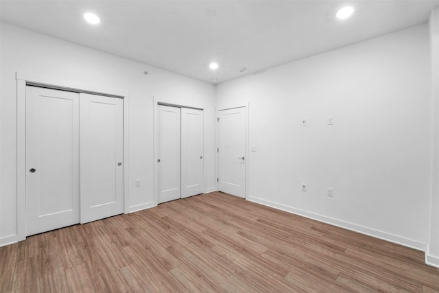 4361 S Congress Ave Unit 333, Austin, TX 78745 - unfurnished bedroom featuring multiple closets, light wood-type flooring, and recessed lighting
